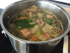 a pot filled with soup sitting on top of a stove