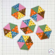 six patchwork squares are arranged on a piece of paper and laid out in the shape of hexagons