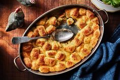 a casserole dish is shown with a spoon in it and some other food on the table