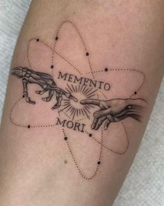 a tattoo on the leg of a woman with two hands reaching for each other, which reads mementoo mori