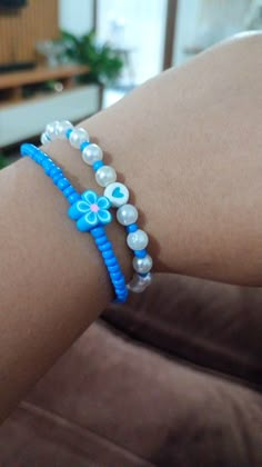 a close up of a person's arm wearing two bracelets with flowers on them