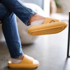 a person wearing yellow shoes sitting on a chair