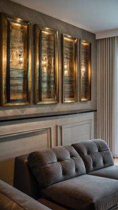 a living room with couches and paintings on the wall