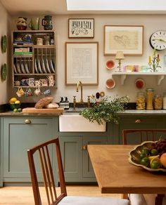 a kitchen filled with lots of green cabinets next to a wooden dining room table and chairs