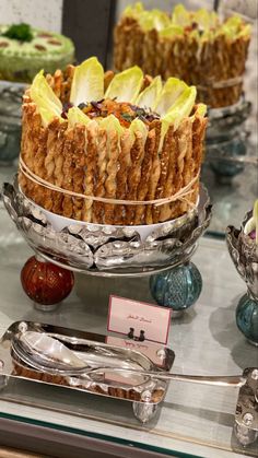 an assortment of desserts on display in a glass case