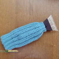 a blue crocheted hat with a toothbrush in it sitting on a table