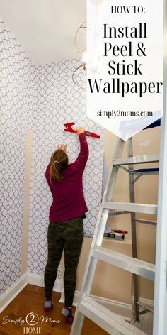 a woman is painting the wall with white paint and she has her hands up in the air