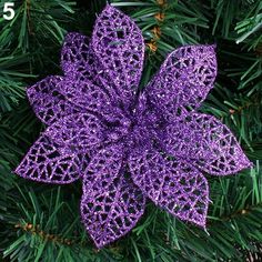 a purple christmas ornament on top of a tree