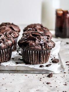 three chocolate muffins sitting on top of a glass plate