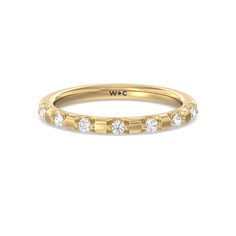 a yellow gold wedding band with five round diamonds on the inside and outside of it