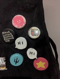 several buttons are placed on the back of a black bag that is open to show what's inside