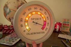 a clock that is sitting on top of a table with some lights in front of it