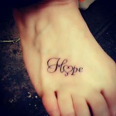 a woman's foot with the word hope tattooed on it