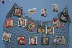 many pictures are hanging on a net with clothes pins