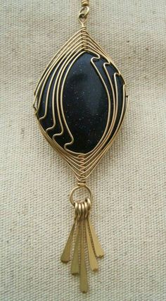 a black and gold brooch sitting on top of a white cloth