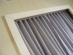 an open window with vertical blinds on the outside