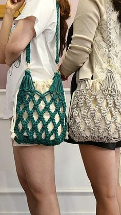 two women standing next to each other with purses on their backs and one holding a cell phone