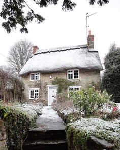 an old stone house with snow on the roof