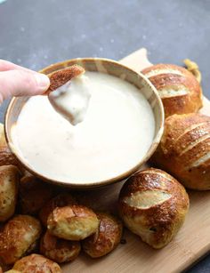 a person dipping dip into some bread rolls