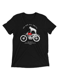 a black t - shirt with an image of a dog on a motorcycle and the words we