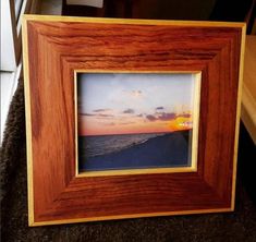 a wooden frame sitting on top of a carpeted floor next to a window sill