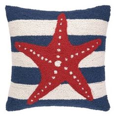 a red starfish on a blue and white striped pillow with stars in the center