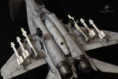 a model jet fighter plane sitting on top of a black table next to other planes