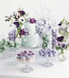 a table topped with lots of cakes and flowers