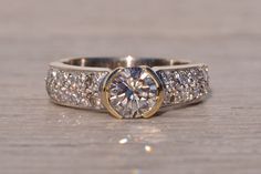 a diamond ring with two rows of diamonds on the band and a center stone in the middle