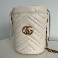 Like New! Used Once And Decided It’s Not My Style. Bought Directly From Gucci Online Currently $1150 Plus Tax Online White Matelass Chevron Leather With A Heart On The Back Antique Gold-Toned Hardware Moir And Microfiber Lining With A Suede-Like Finish Double G Detachable Key Ring 2 Card Slots Chain Strap With 23.6" Drop Drawstring Closure Can Also Be Worn As A Cross Body Bag 5.5"W X 6.7"H X 5.1"D Made In Italy Classic Gucci Bucket Bag, Luxury Gucci Cream Bag, Luxury Cream Gucci Bag, Designer Gucci Bucket Shoulder Bag, White Gucci Bag For Everyday Luxury, Luxury White Bucket Shoulder Bag, White Luxury Gucci Shoulder Bag, Gucci Formal Bucket Bag, Luxury White Gucci Shoulder Bag