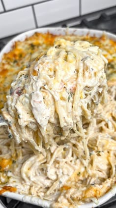 a white bowl filled with pasta and cheese on top of an oven burner next to a stove