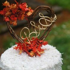 a heart shaped cake decorated with leaves and the word love spelled in cursive letters