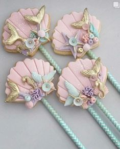 four decorated cookies sitting on top of a table next to straws and toothbrushes