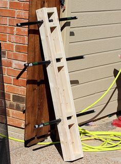 a ladder leaning up against a building next to a fire hydrant and hoses