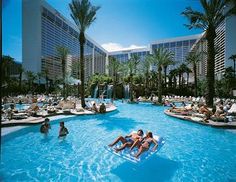 people are floating on inflatable rafts and having fun at the hotel pool