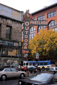 cars are parked in front of an outdoor bar and restaurant on the corner of a city street