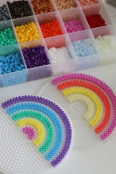 there are many different colors of beads in the trays on the table next to each other