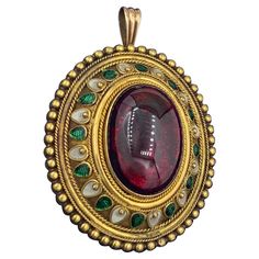 This is one of the most stunning antique 19th Century Garnet Enamel jewels we have seen. The Etruscan Archeological Revival pendant features a magnificent blood red Bohemian Garnet cabochon of gorgeous color and size set in a 14 Karat Gold Enamel beaded design. The garnet is surrounded by magnificent gold and enamel work of the highest quality. The pendant is very characteristic of the work of the master Italian jeweler Castellani, who created Etruscan Revival jewels of the highest quality in th Antique Oval Pendant Jewelry With 17 Jewels, Antique Jeweled Jewelry, Antique Cabochon Jewelry For Ceremonial Occasions, Victorian Cabochon Ceremonial Jewelry, Antique Jeweled Yellow Gold Jewelry, Antique Yellow Gold Jeweled Jewelry, Ornate Jeweled Pendant Jewelry, Traditional Cabochon Necklace For Formal Occasions, Traditional Oval Pendant Jewelry For Formal Occasions