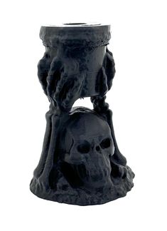 a black candle holder with a skull on it