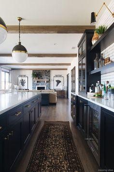 a kitchen with an area rug on the floor and black cabinets in front of it