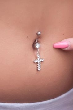 a woman's belly with a cross and ball chain attached to the back of her stomach