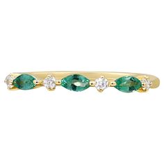 a yellow gold ring with green and white stones