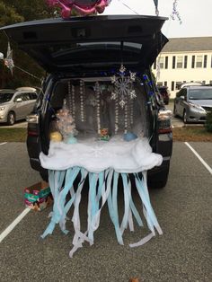 the trunk of a car is decorated with blue ribbons and snowflakes,