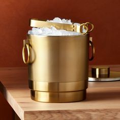 a gold ice bucket on a wooden table