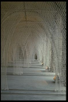 the interior of a building with white netting covering it's walls and walkways