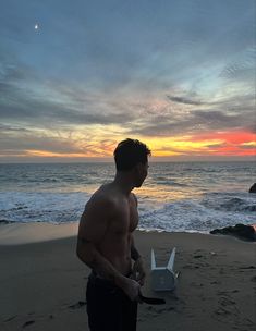 a man standing on top of a sandy beach next to the ocean