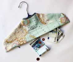 the money is laying on top of the map and it's zippered pouch