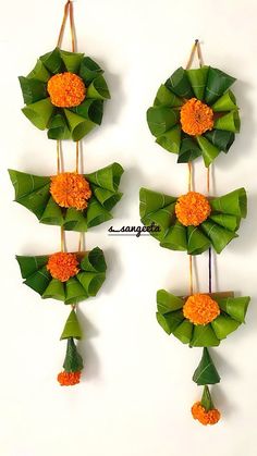 four pieces of paper with flowers and leaves attached to them on a white wall background