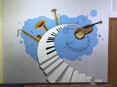 a wall with musical instruments painted on it and a staircase leading up to the door