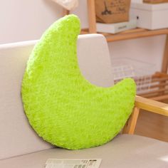 a banana shaped pillow sitting on top of a white couch next to a wooden table